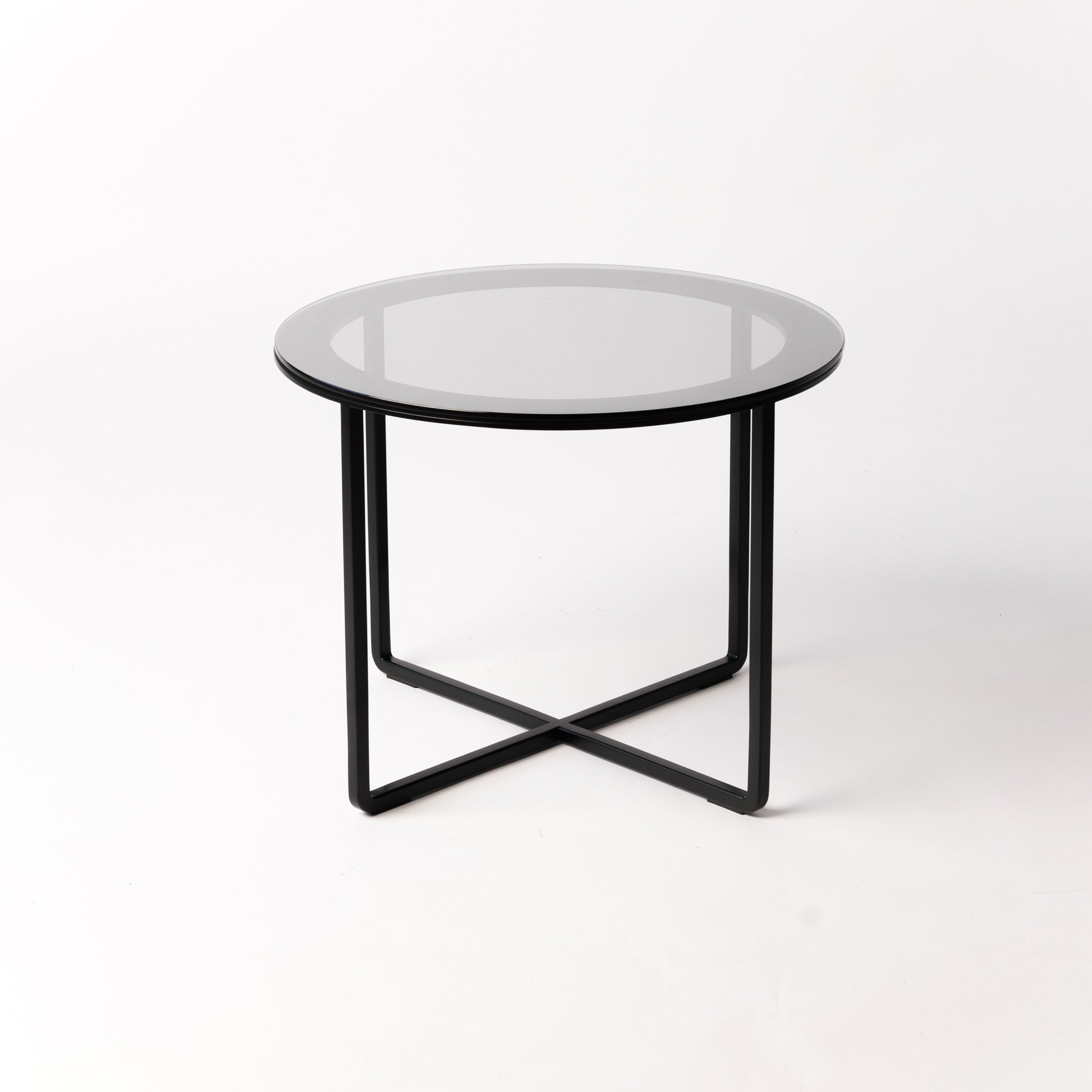 Minimalist Circo X Side Table - side angle highlighting the architectural black steel base supporting glass top